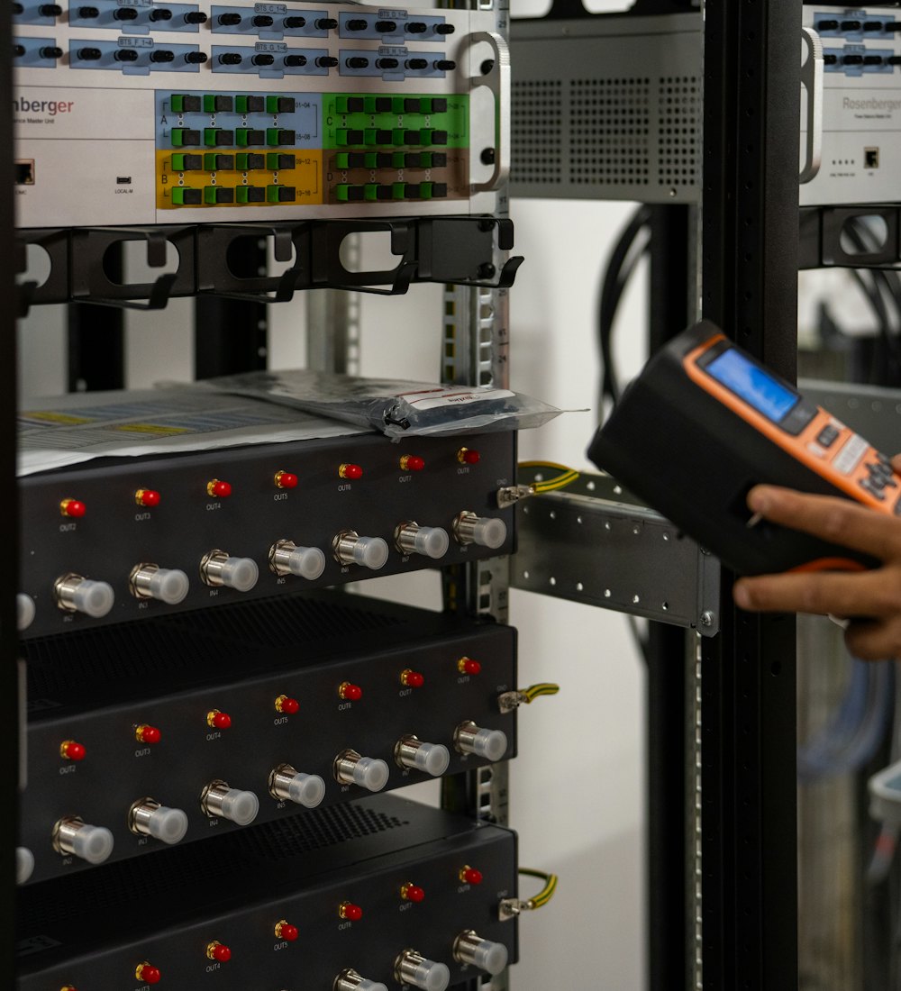 Técnico revisando un rack de equipos de red con un instrumento de diagnóstico